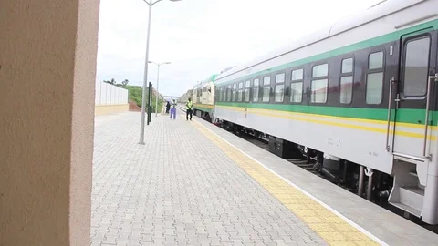 Wide view of a train as people walk in the distance Stock Footage 75893371