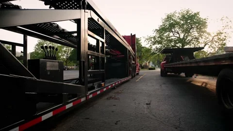 Wide view of Two trucks with a car hauler stand in the parking lot. Rear view Stock-Footage 158359347