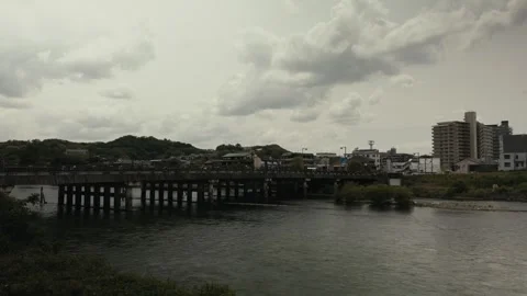 Wide view of Uji River bridge and town skyline under cloudy sky in Japan 스톡 동영상 339005215