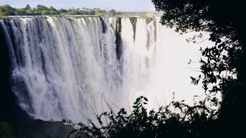 Wide view of Victoria Falls cascading into the gorge, framed by trees Stock-Footage 345521092