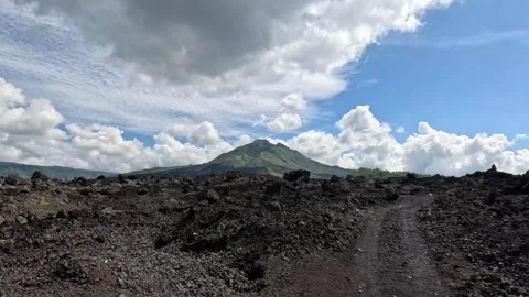 Wide view of volcanic eruption valley with lava fields and active volcano in Stock Footage 339960292