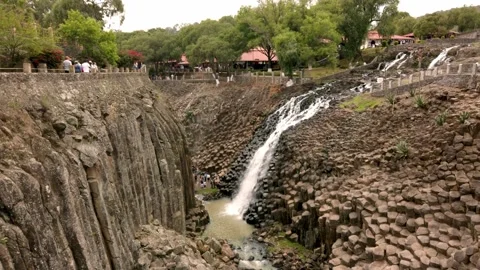 Wide View of Waterfall Flowing Through Basalt Canyon at Volcanic Rock Formation Stock Footage 337558147