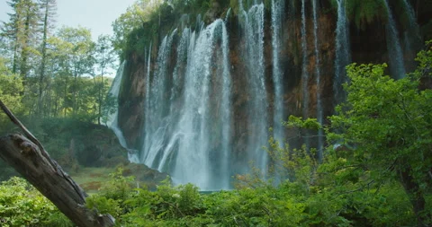 Wide view of waterfalls cascading into forest pond in Plitvice Lakes Croatia Stock Footage 310239934