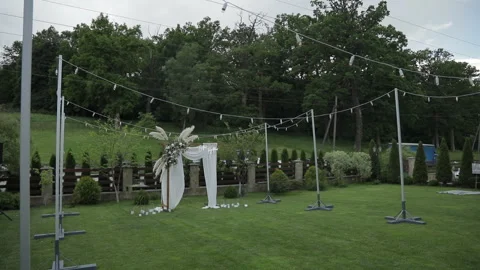 A wide view of the wedding ceremony area and the arch decorated with white Stock Footage 324814779