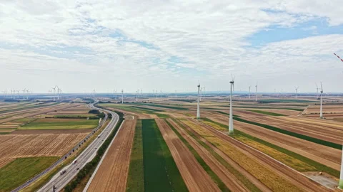 Wide view of wind turbines in a large agricultural field on a clear day with Stock Footage 342785336
