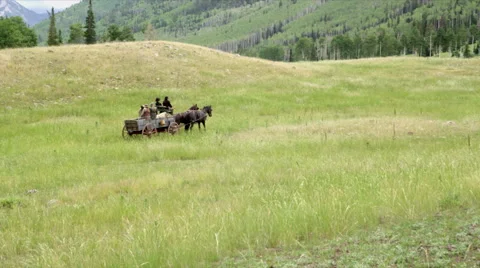 Wide of Wagon going through large field Stock Footage 43399546