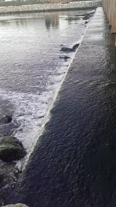 A wide waterfall current under a bridge in Wadi. An close to smooth flowing.. Stock Footage 285785724