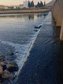 A wide waterfall current under a bridge in Wadi. Close to flowing water Stock Photos