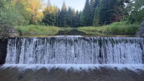 Wide waterfall on mountain river surrounded by green forest 4K static shot Stock Footage 341851356