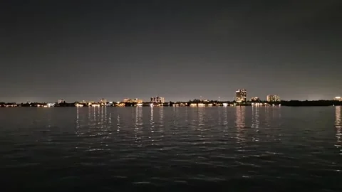 Wide Waterfront Skyline at Night Reflected in Calm Water Stock Footage 345665014