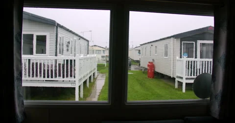 Wide zoom Shot of rain on a static caravan window with static caravans in Stock Footage 346815095