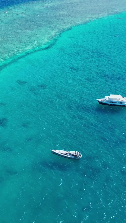 Wideangle image displaying elegant boat near colorful reef and lagoon Vídeo Stock 347397682