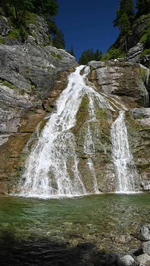 Wideangle vertical shot of a waterfall with its pond in the foreground, slow-mo Stock-Footage 260878538