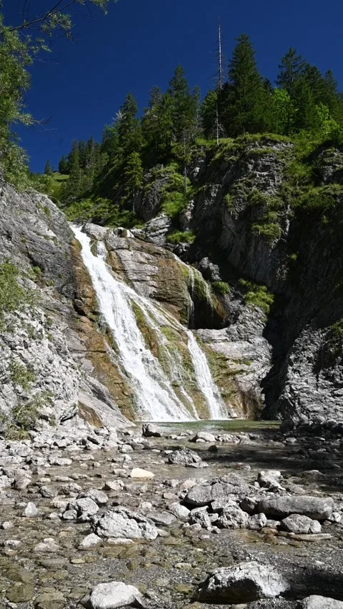 Wideangle vertical shot of a waterfall in summer, slow motion Video stock 260878318
