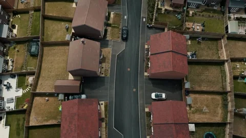 A wider move looking directly down over a local street in a housing estate Stock Footage 296813547