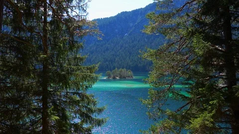 Wider view through trees of a mountain lake. Zugspitze Eibsee Stock Footage 88795089