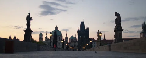 Widescreen centered shot of statues of St. Charles Bridge in Prague at sunrise Stock Footage 284496027