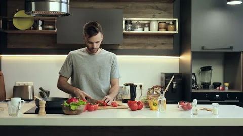 Wife trying to take selfies, while her husband is cooking. Stock Footage 100181627