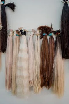 Wig blanks on the wall wig maker. Bundle of natural hair for hair extensions Stock Photos