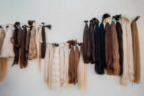 Wig blanks on the wall wig maker. Bundle of natural hair for hair extensions Stock Photos