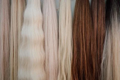 Wig blanks on the wall wig maker. Bundle of natural hair for hair extensions Foto stock