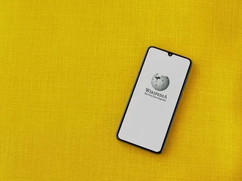 Wikipedia app launch screen with logo on the display of a black mobile smartp Stock Photos