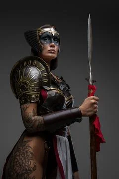 Wild amazon dressed in dark armor holding spear 库存照片