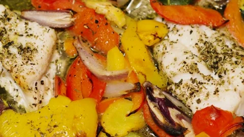 Wild caught atlantic Cod fillets with mediterranean diet vegetables in bubbling Stock Footage 329463398