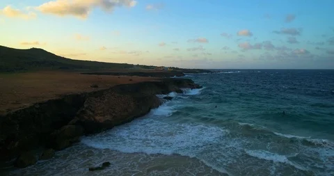 Wild coast cliff pan down to beach with beautiful waves smashing Stock-Footage 97768252