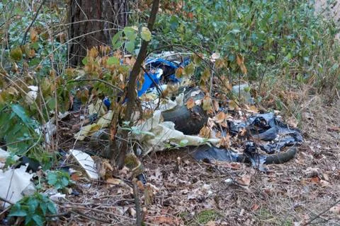 Wild dump, tires, foils in the woods, illegal dump Stock Photos