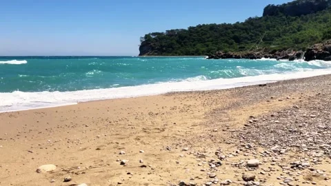 Wild Empty Sandy Beach with Turquoise Waves and Rocky Coast 4K Stock-Footage 330936040