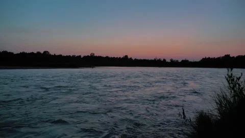 The wild forest river flows fast at dusk against the sunset sky. Mysterious Stock Footage 171275584