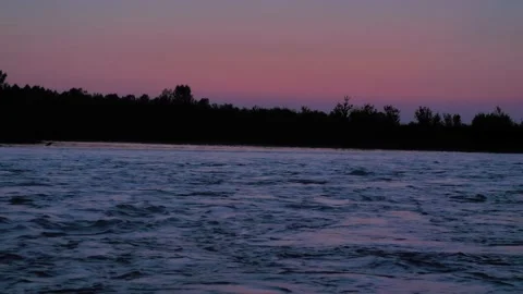 The wild forest river flows fast at dusk against the sunset sky. Mysterious Vídeo Stock 171275641