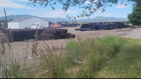 Wild grasses sway gently in front of a train yard, Montana 库存影片 340428189