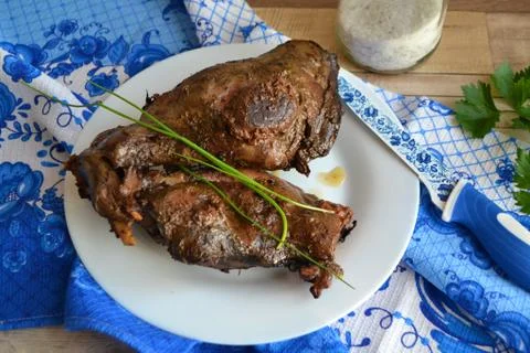 Wild hare (or wild rabbit)  roasted with vegetables, on blue and white tradit Stock Photos