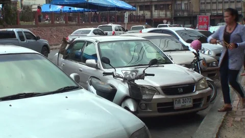 Wild macaques attack a silver car. Thai woman scares them with a slingshot. Stock Footage 112999457