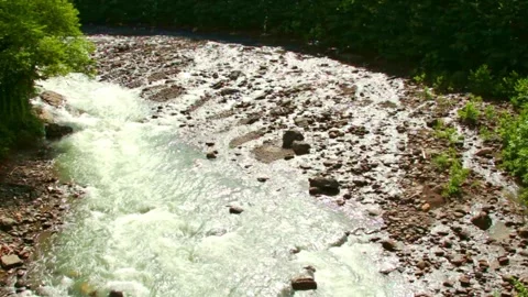 Wild mountain river flowing through stone boulders, Water clear stream river flo Stock Footage 244999942