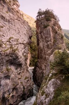 A wild mountain river squeezing between two craggy rocks in a gorge Foto stock