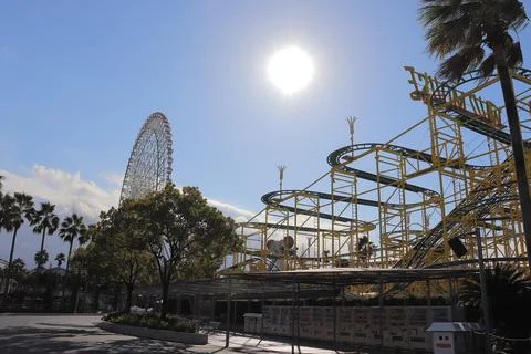 The Wild Mouse roller coaster and the Aurora Ferris Wheel silhouetted by the sun Stock Photos