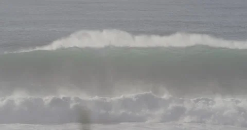 Wild ocean waves splashing and breaking on sandy beach on sunny day in Nazare Stock Footage 160769069