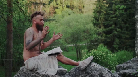 Wild Primitive Savage Dancing with Modern Tablet PC or Mobile Computer in Forest Stock Footage 131291575