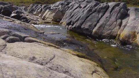 Wild river between stones forms a beautiful natural peaceful stream Stock Footage 115444389
