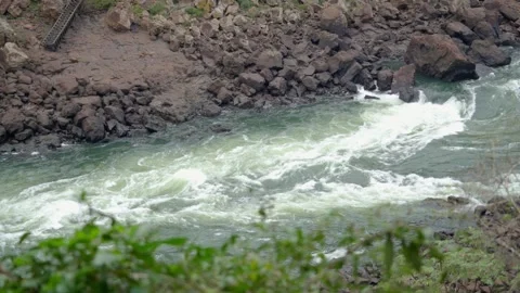 Wild river rapids rushing powerfully over dark rocks in slow motion at Iguazu Video stock 345032240