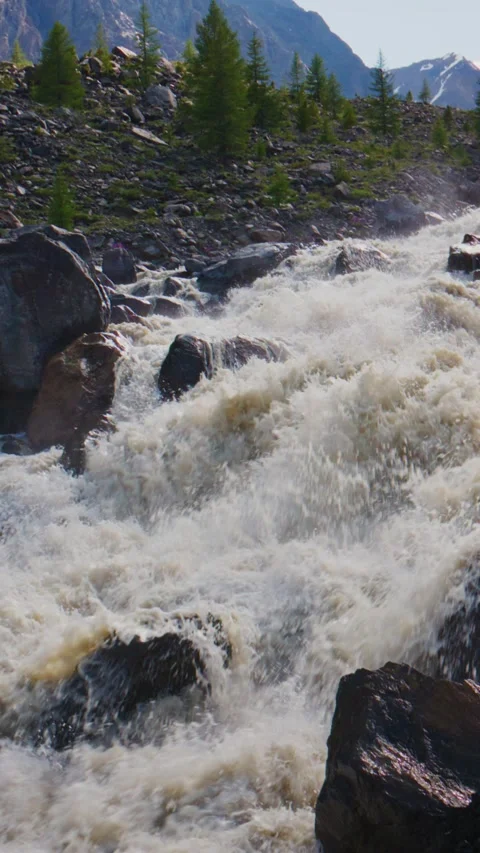 Wild river surges through rugged terrain with splashing waves Stock Footage 335570420