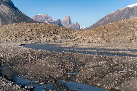 Wild river winds through remote, stony arctic landscape. A big moraine and Stock Photos