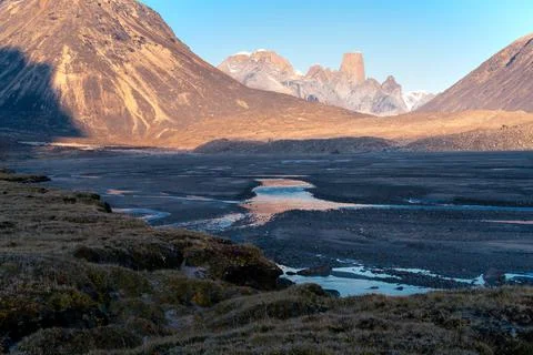 Wild river winds through remote, stony arctic landscape. A big moraine and Stock-Fotos