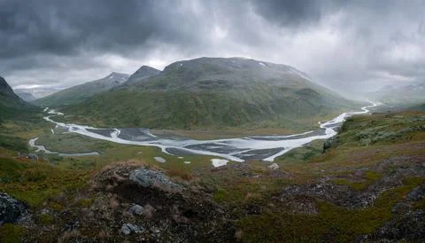 Wild river winds through remote rough arctic valley on a very cloudy and rainy Stock Photos
