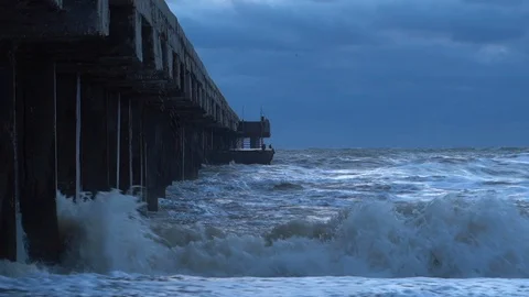Wild waves are splashing and hitting piles of the pier at the Black Sea coast. Stock Footage 127256005