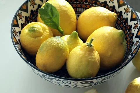 Wild yellow-green unripe lemons in plate. Environmentally friendly product. Eco Stock Photos