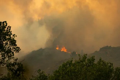 Wildfire burning hills creating dense smoke haze Stock-Fotos